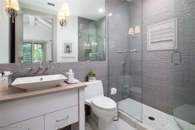 bathroom featuring vaulted ceiling, toilet, vanity, a shower with shower door, and tile walls