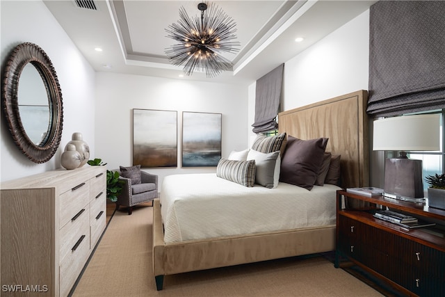 carpeted bedroom featuring a chandelier and a tray ceiling