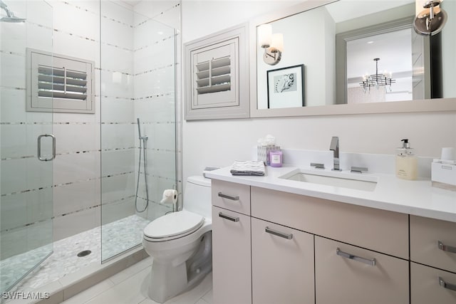 bathroom featuring vanity, tile patterned flooring, toilet, a shower with shower door, and a chandelier