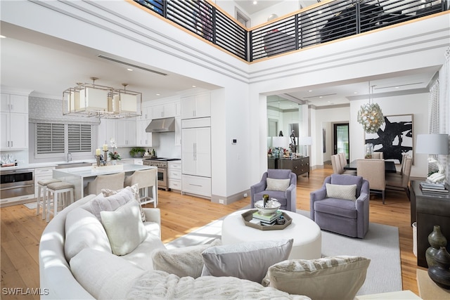 living room with light wood-type flooring and a high ceiling