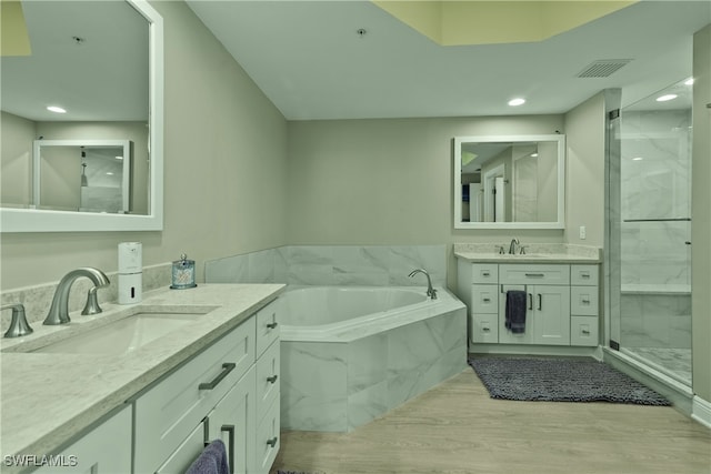 bathroom with hardwood / wood-style floors, vanity, and separate shower and tub