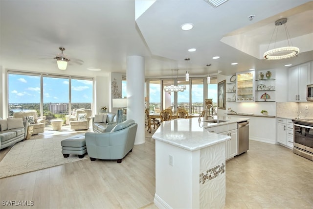 kitchen with pendant lighting, white cabinets, and a kitchen island with sink