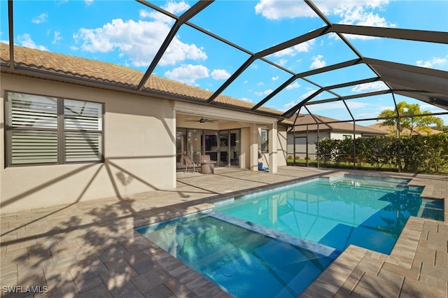 view of swimming pool with a lanai, a patio area, and ceiling fan