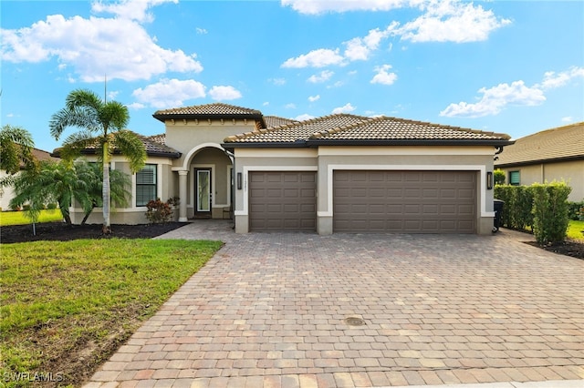 mediterranean / spanish-style house featuring a garage and a front yard