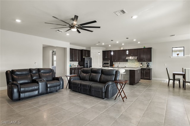 living room featuring sink, light tile patterned floors, and ceiling fan