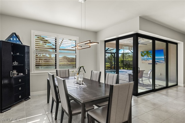 tiled dining room featuring ceiling fan with notable chandelier