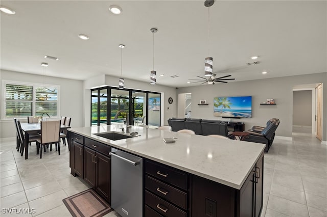 kitchen with sink, dishwasher, ceiling fan, hanging light fixtures, and an island with sink