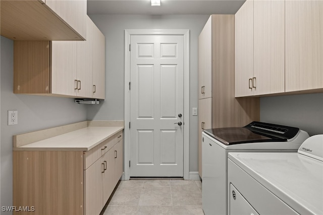 laundry area with washing machine and dryer, cabinets, and light tile patterned flooring