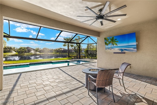 view of swimming pool with a water view, ceiling fan, a patio area, and glass enclosure