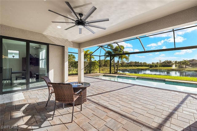 view of patio / terrace with a water view, ceiling fan, and glass enclosure