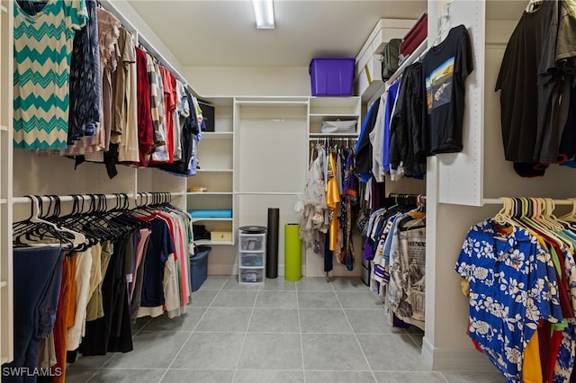 walk in closet with light tile patterned floors