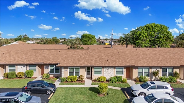 4629 SE 5th Pl Unit 12, Cape Coral, FL 33904 - view of front of house with uncovered parking, a shingled roof, a front yard, and stucco siding