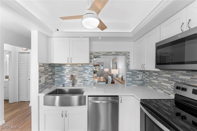 4629 SE 5th Pl Unit 12, Cape Coral, FL 33904 - kitchen with stainless steel appliances, a ceiling fan, a sink, light countertops, and white cabinets