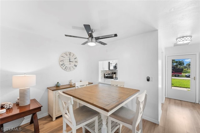 dining room with ceiling fan and light hardwood / wood-style flooring