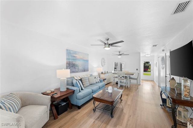 living room with ceiling fan and light hardwood / wood-style flooring