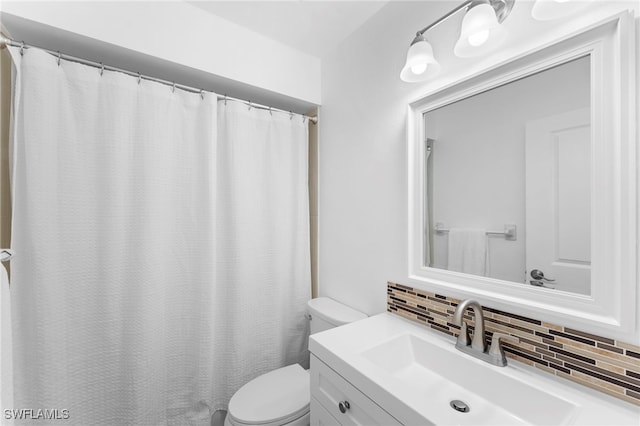 bathroom with vanity, toilet, and tasteful backsplash