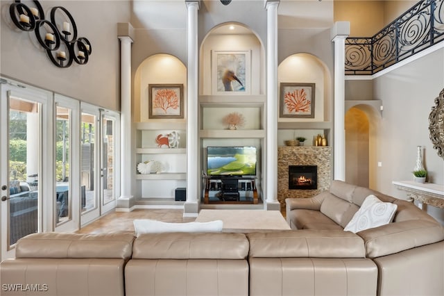 living room with built in shelves and a high ceiling