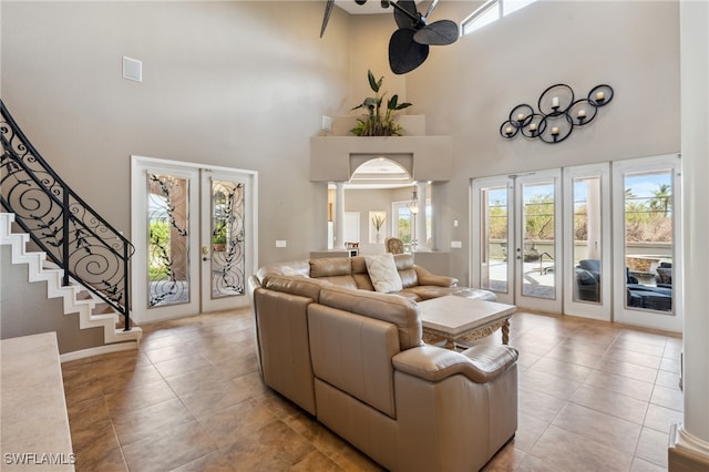 tiled living room with a high ceiling, french doors, and decorative columns