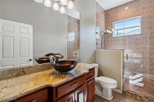 bathroom featuring tile patterned flooring, vanity, toilet, and a shower with door