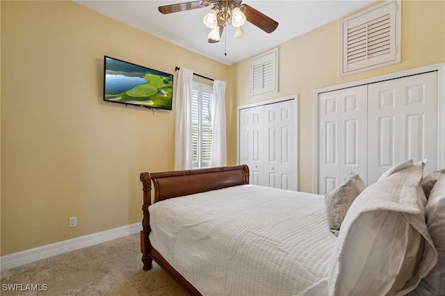 bedroom with ceiling fan and multiple closets