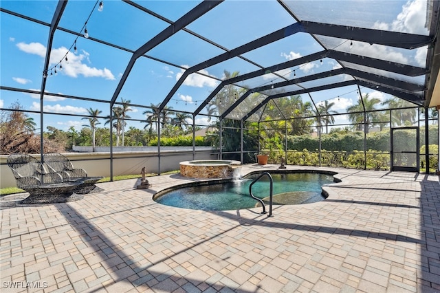 view of pool with glass enclosure, a patio, and an in ground hot tub