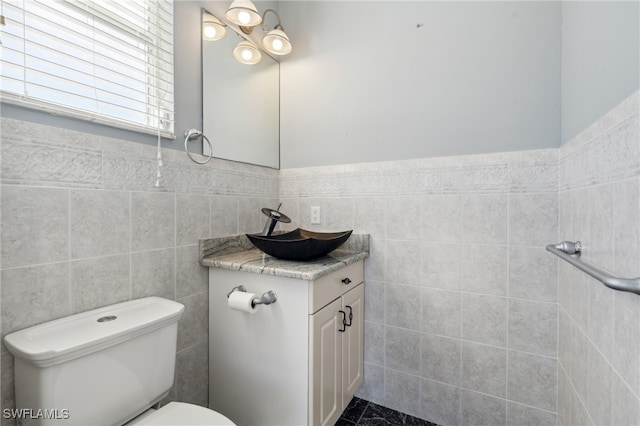 bathroom featuring tile walls, vanity, and toilet