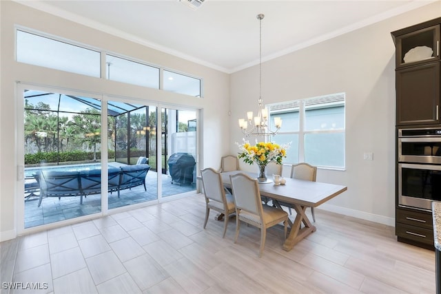 dining area with visible vents, an inviting chandelier, ornamental molding, light wood-style floors, and baseboards