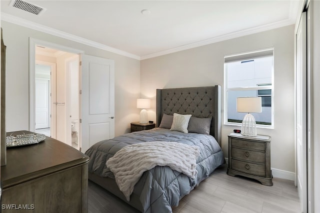 bedroom with baseboards, visible vents, and crown molding