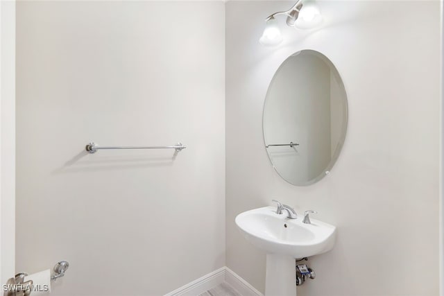 bathroom with a sink and baseboards