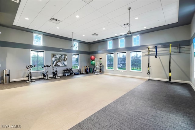 workout area featuring baseboards, visible vents, and carpet flooring