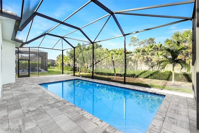 pool with glass enclosure and a patio area