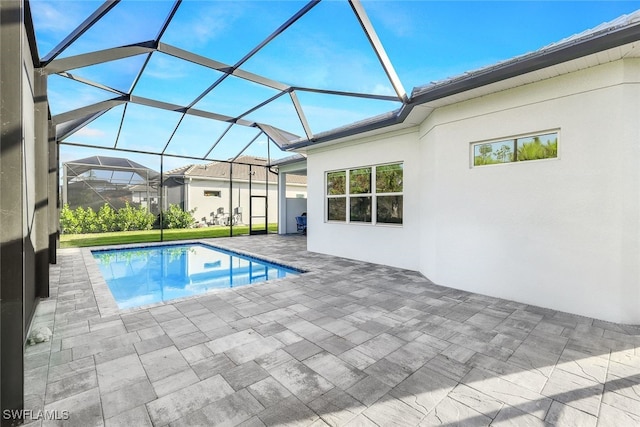 view of swimming pool with glass enclosure and a patio