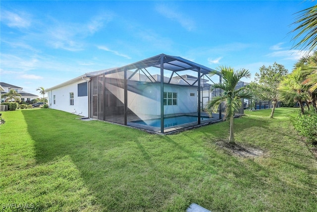 back of house featuring a lanai and a lawn