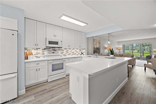 kitchen with white cabinets, light wood-type flooring, and white appliances