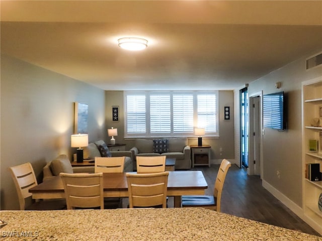 dining space featuring built in shelves and dark hardwood / wood-style floors