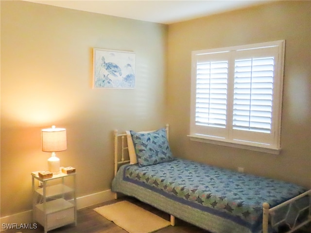 bedroom with dark hardwood / wood-style flooring