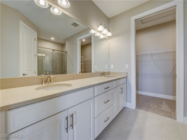 bathroom with tile patterned flooring, vanity, and walk in shower