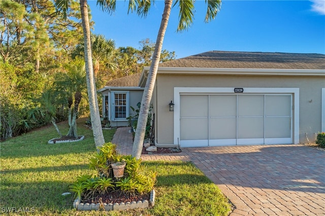 ranch-style home with a garage and a front lawn