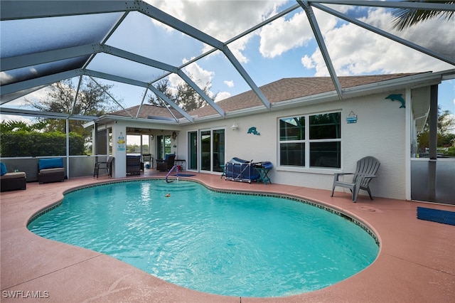 view of pool with glass enclosure and a patio