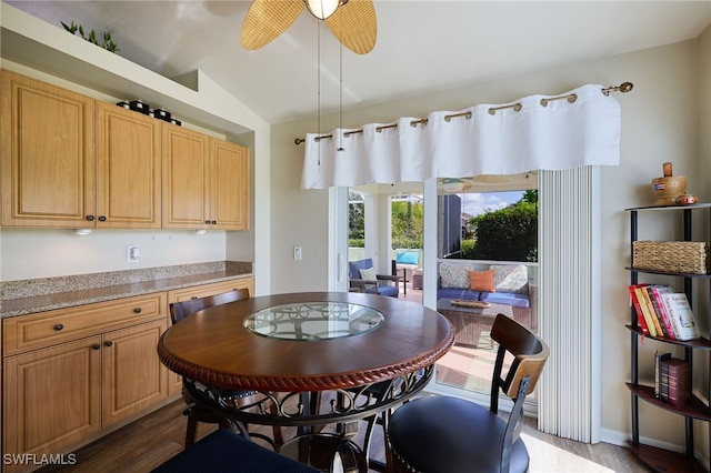 dining room with vaulted ceiling, dark hardwood / wood-style floors, and ceiling fan