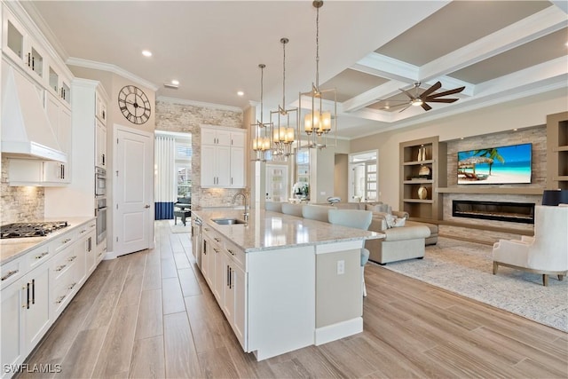 kitchen with sink, white cabinetry, decorative light fixtures, a center island with sink, and appliances with stainless steel finishes