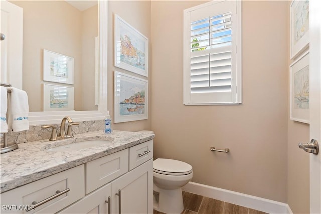 bathroom with hardwood / wood-style flooring, vanity, and toilet