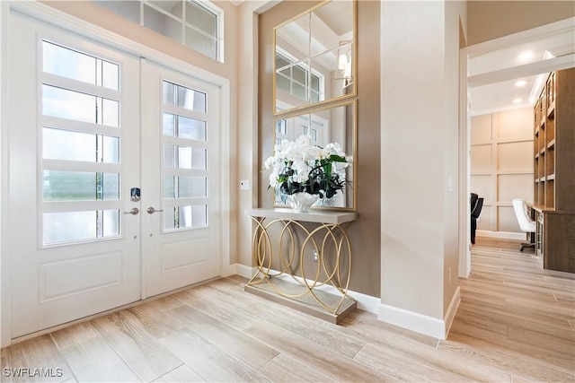 doorway with french doors and light hardwood / wood-style floors