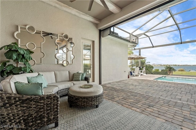 view of patio / terrace featuring an outdoor living space, ceiling fan, and glass enclosure