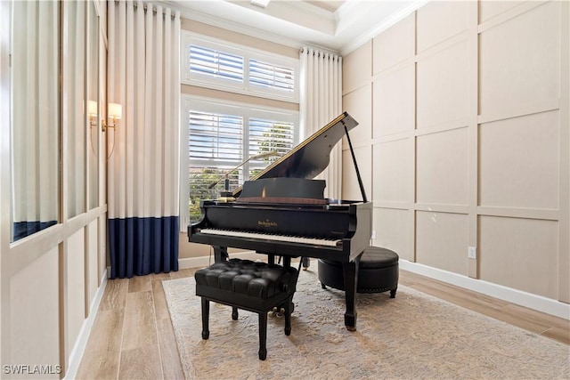 misc room with light hardwood / wood-style flooring, ornamental molding, and a high ceiling