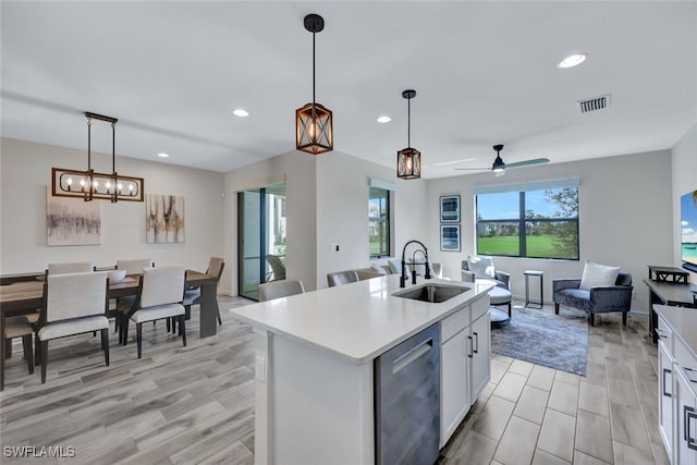 kitchen featuring white cabinetry, sink, ceiling fan, an island with sink, and decorative light fixtures