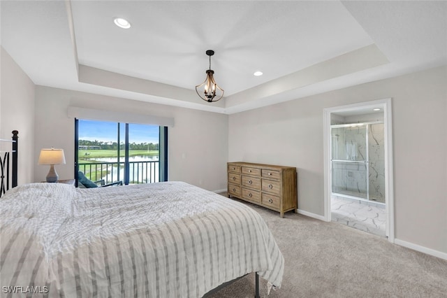 carpeted bedroom featuring ensuite bathroom, access to exterior, and a tray ceiling