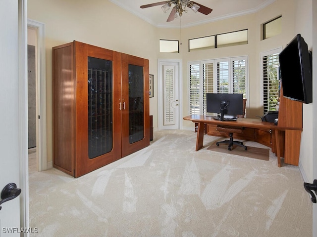 carpeted office space with ceiling fan, a towering ceiling, crown molding, and french doors