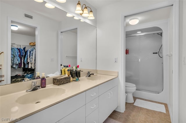 bathroom with tile patterned flooring, vanity, toilet, and a shower with shower door