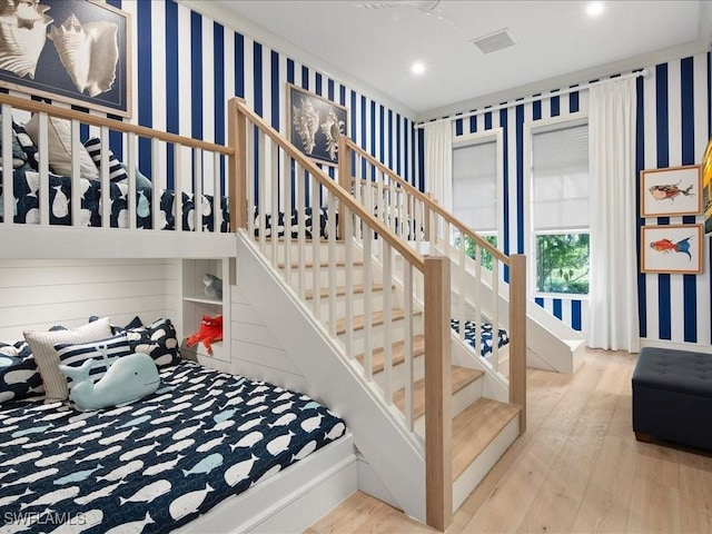 stairway featuring wallpapered walls, baseboards, wood finished floors, and recessed lighting